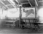 Interior of the 1st Day Bombardment Group intelligence office in France, 1918. Note the photo mosaic map of the group's operating sector over the...