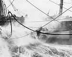 Oiler tanker desperately trying to refuel ship in heavy seas as typhoon strikes